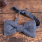 Dusty blue bow tie made from sustainable linen on wooden table